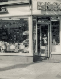 A black and white photograph of an old shopfront.