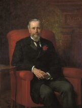 A painting of a light-skinned man in a suit, sitting in a red armchair.