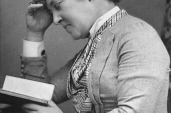 A black and white photograph of a woman reading.