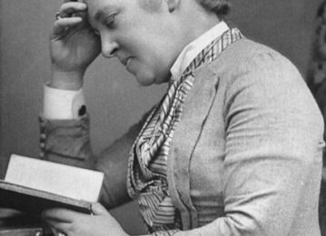 A black and white photograph of a woman reading.