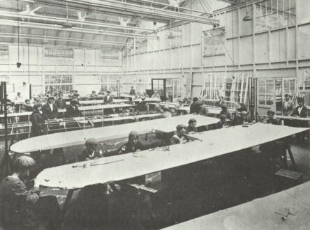 A black and white photograph of women constructing aircraft wings.