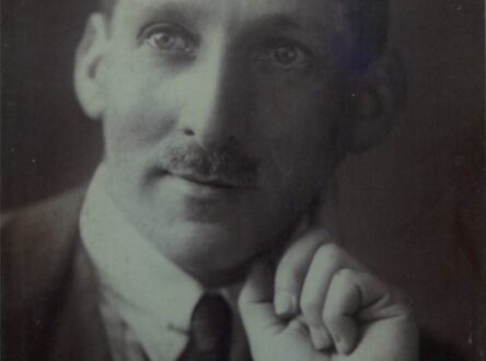 A black and white photographt of a white man leaning on his hand.