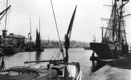Black and white photograph of boats at a dock.
