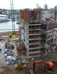 A building being constructed, covered in scaffolding.