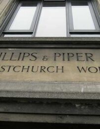 Photograph of words engraved on an old building above an entryway.