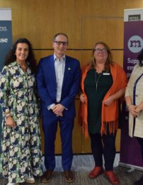 Four people standing in front of banner stands.